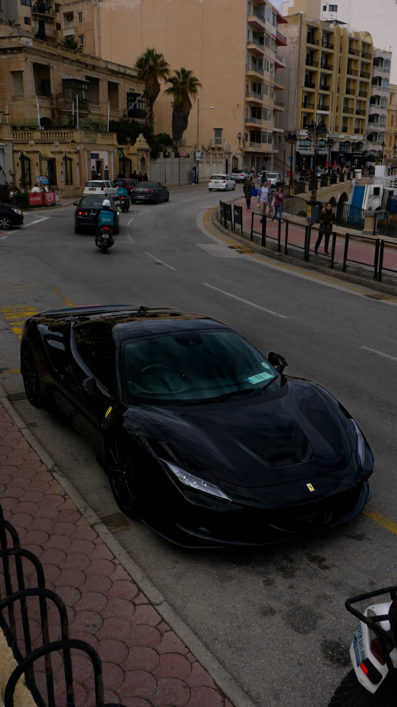 A black luxury sports car parked on a busy city street.